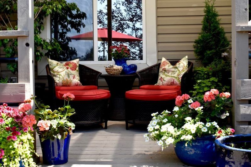 Macetas con flores y cojines en tonos vivos, embellecen la decoración del patio