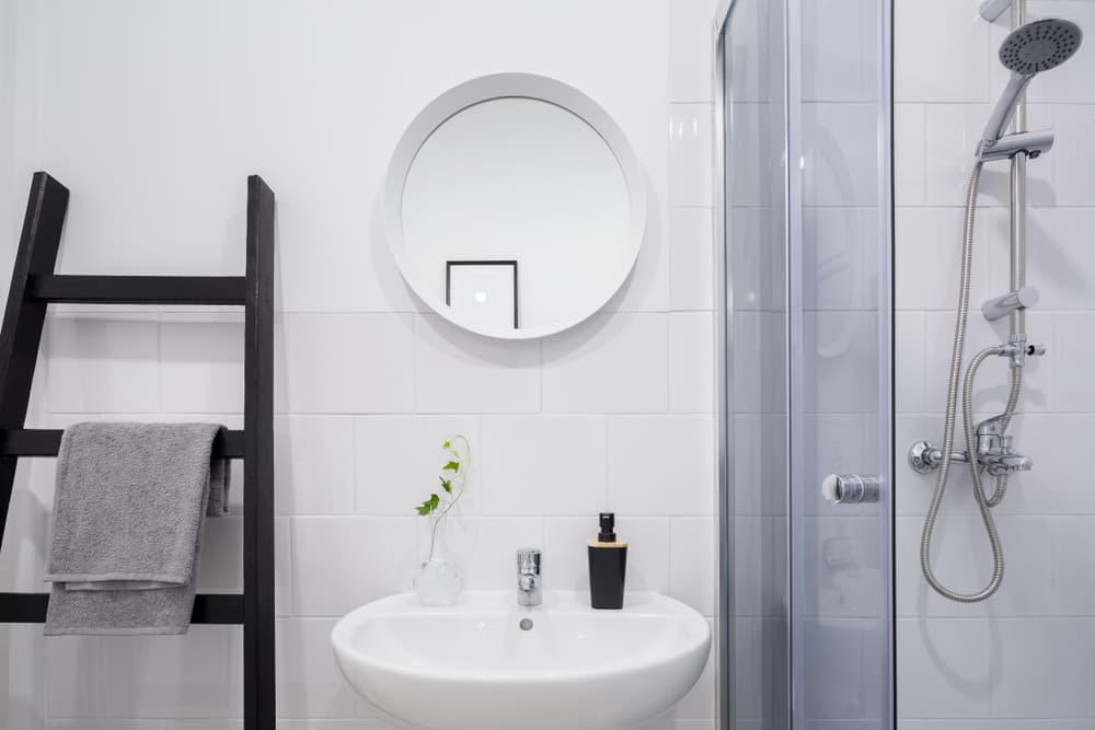 Cómo decorar un baño pequeño y sin gracia? Agrega una escalera para colgar las toallas, o la salida de baño.