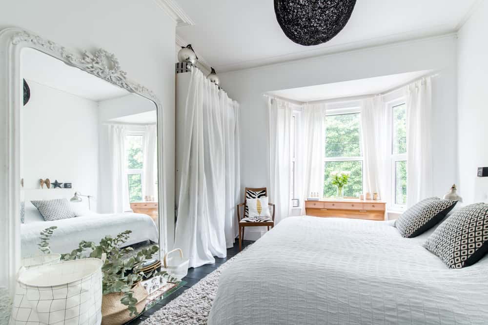 En la decoración de dormitorios pequeños un espejo frente a la cama ayuda visualmente a que luzca más grande.