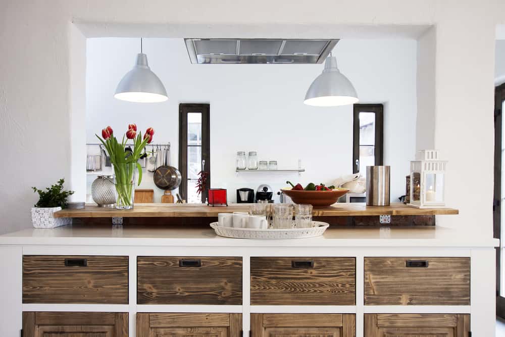 En la cocina puedes crear una decoración rústica colocando cajones de madera bajo el tope y suspendiendo un par de lámparas de metal.