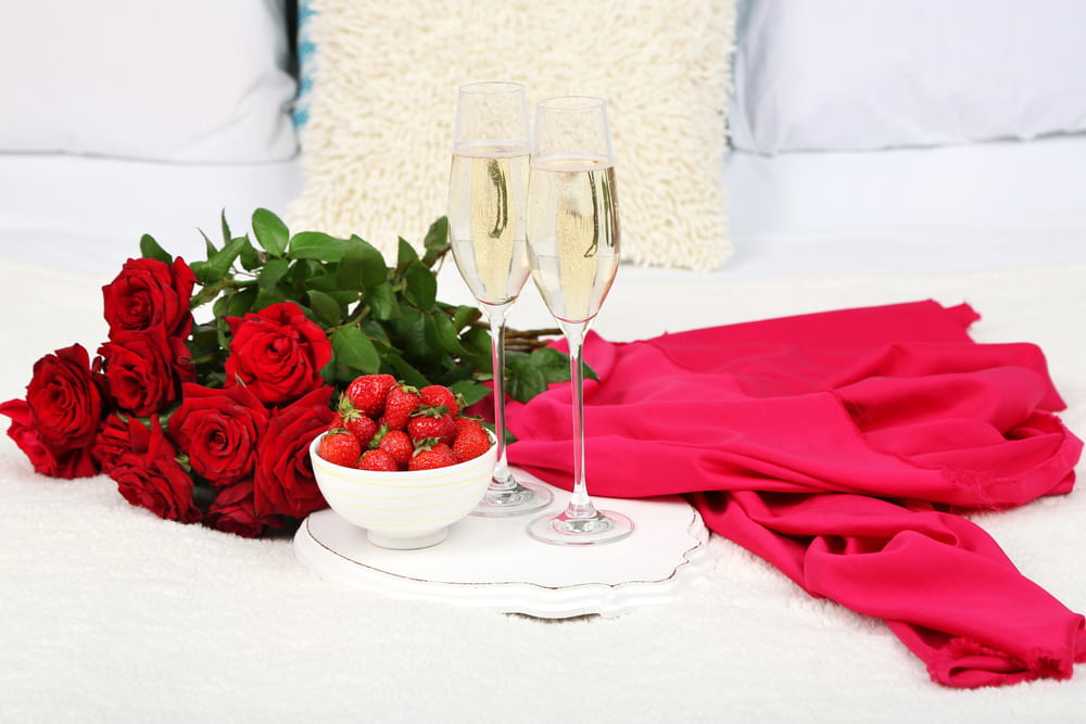 El color rojo no puede faltar en una cena romántica en casa. Acompaña una deliciosa champaña con fresas y no olvides decorar con rosas rojas para crear una atmósfera que invite disfrutar una noche de desbordada de pasión.. 