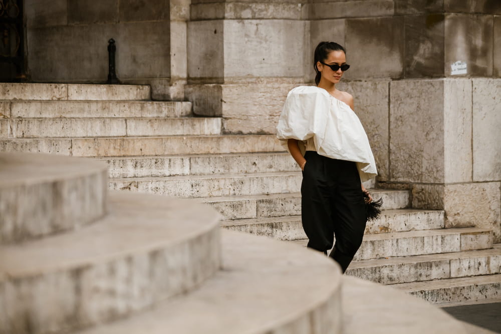 Un pantalón negro combinado con una blusa blanca y de volantes disimula las caderas anchas creando un balance ideal en tu forma de cuerpo.