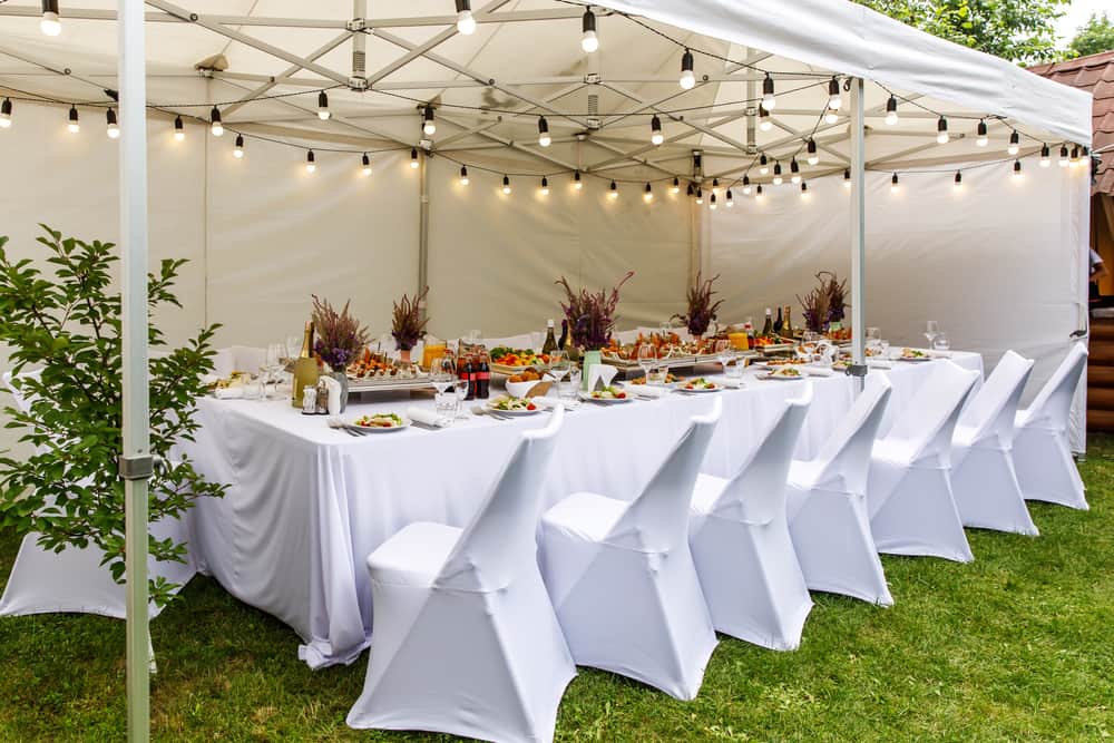 El blanco es un color super chic para una outdoor party. Coloca un toldo lleno de bombillas suspendidas y crea la atención en la mesa para tus invitados.