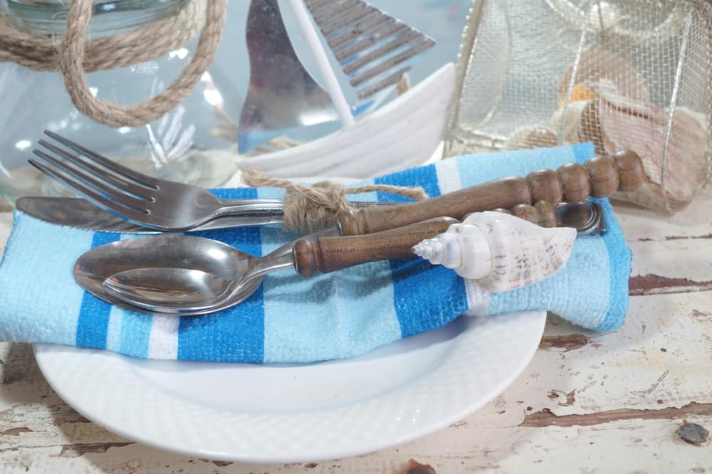 En las casas en la playa la mesa de comedor es un punto focal. Utiliza adornos que evoquen el estilo marino. Conchas, caballitos de mar, caracoles etc.